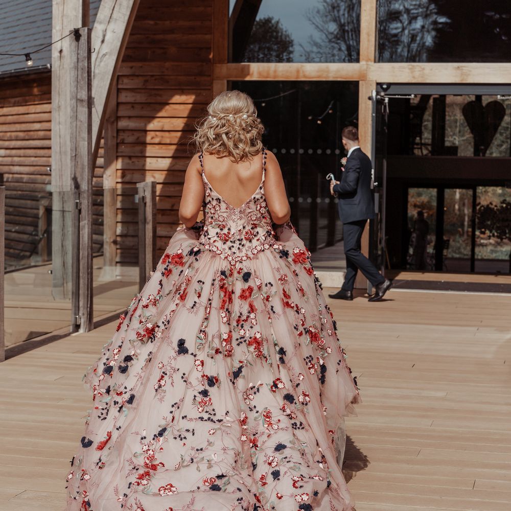 Bride walks to wedding venue whilst lifting bridal gown
