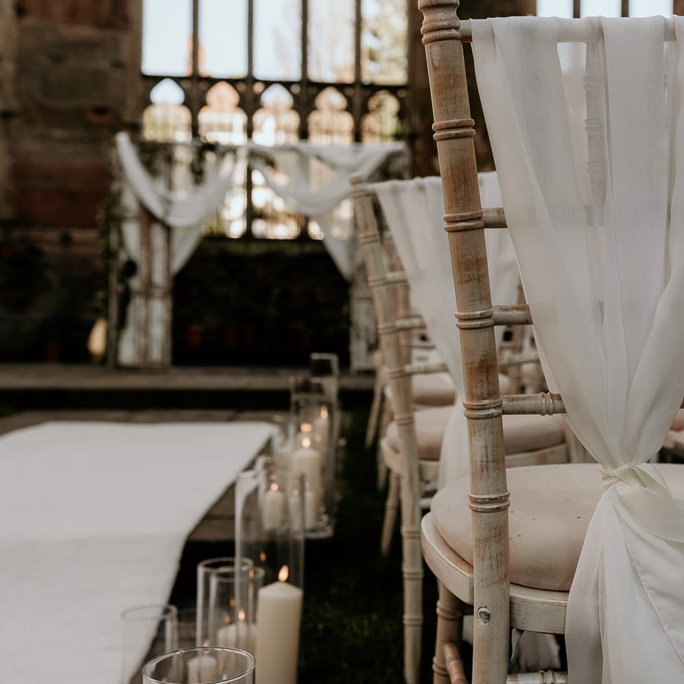 Wooden chairs with fabric chair back decor tied over the back 