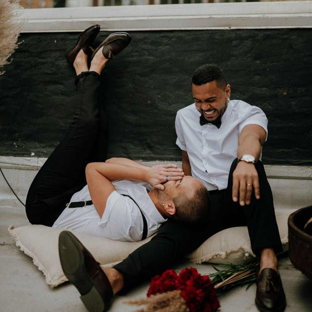 Grooms laughing with each other at New York rooftop wedding