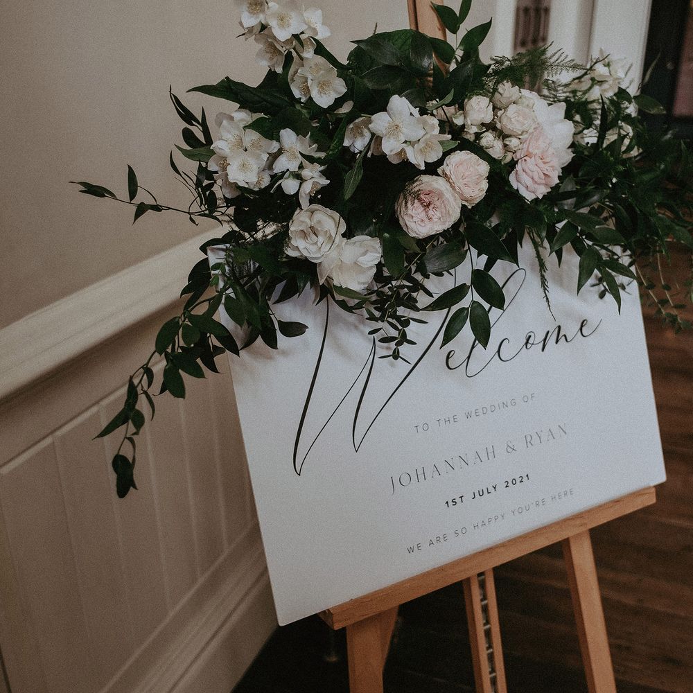 Wedding stationery in classic white surrounded by white florals and green foliage