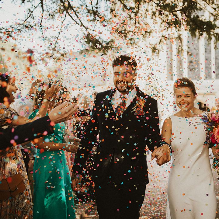 Colourful wedding confetti moment in a church courtyard 