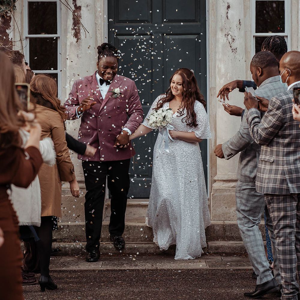 Bride & groom leave as wedding guests throw confetti around them