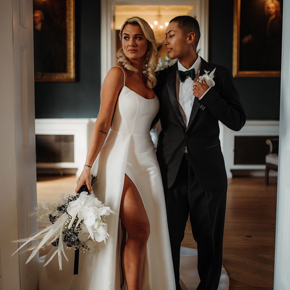 LGBTQI+ couple in a tuxedo suit and princess wedding dress with front slit and pearl wedding shoes at Hodsock Priory 
