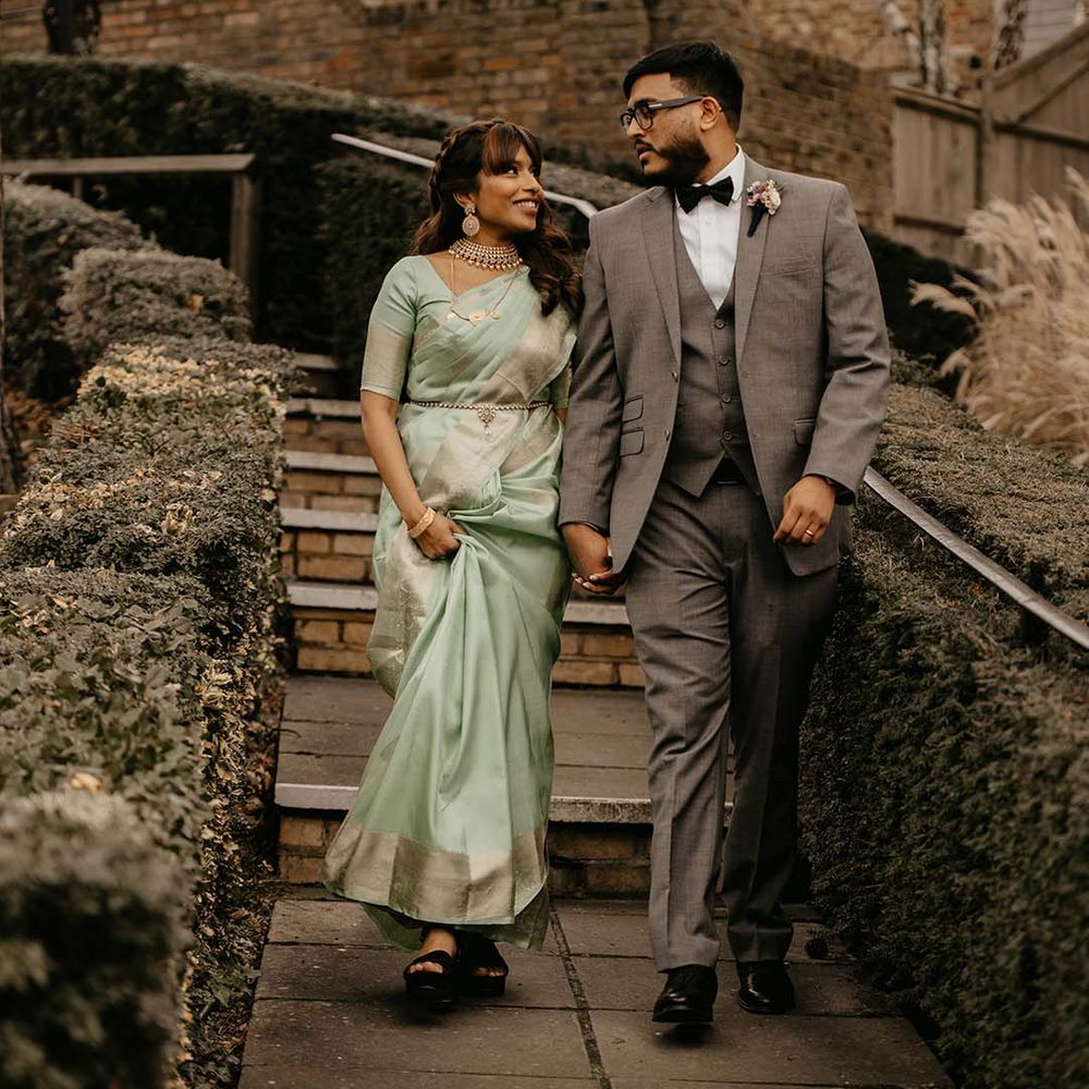 Bride in mint green saree and groom in grey suit walking around the grounds of The Petersham Hotel 