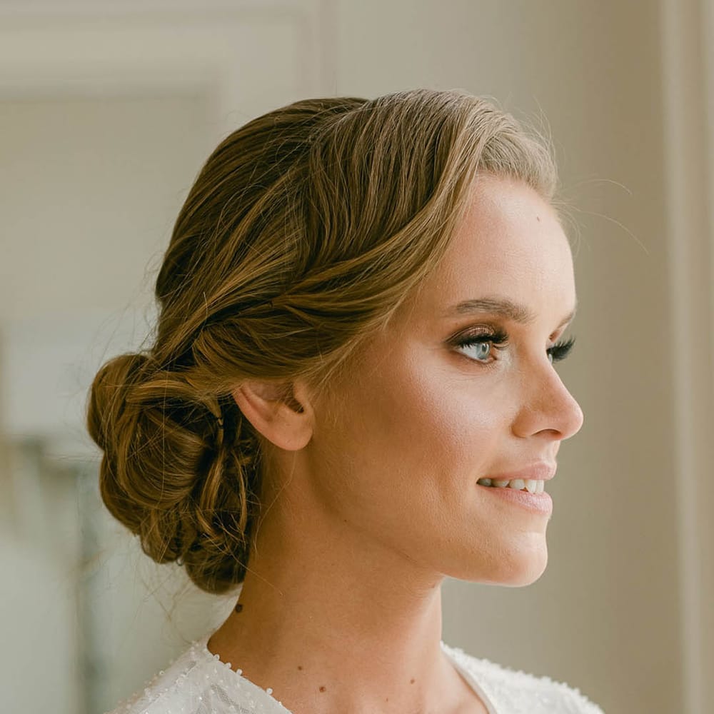 Bridal updo hairstyle with glam and glowy makeup in sparkly number 