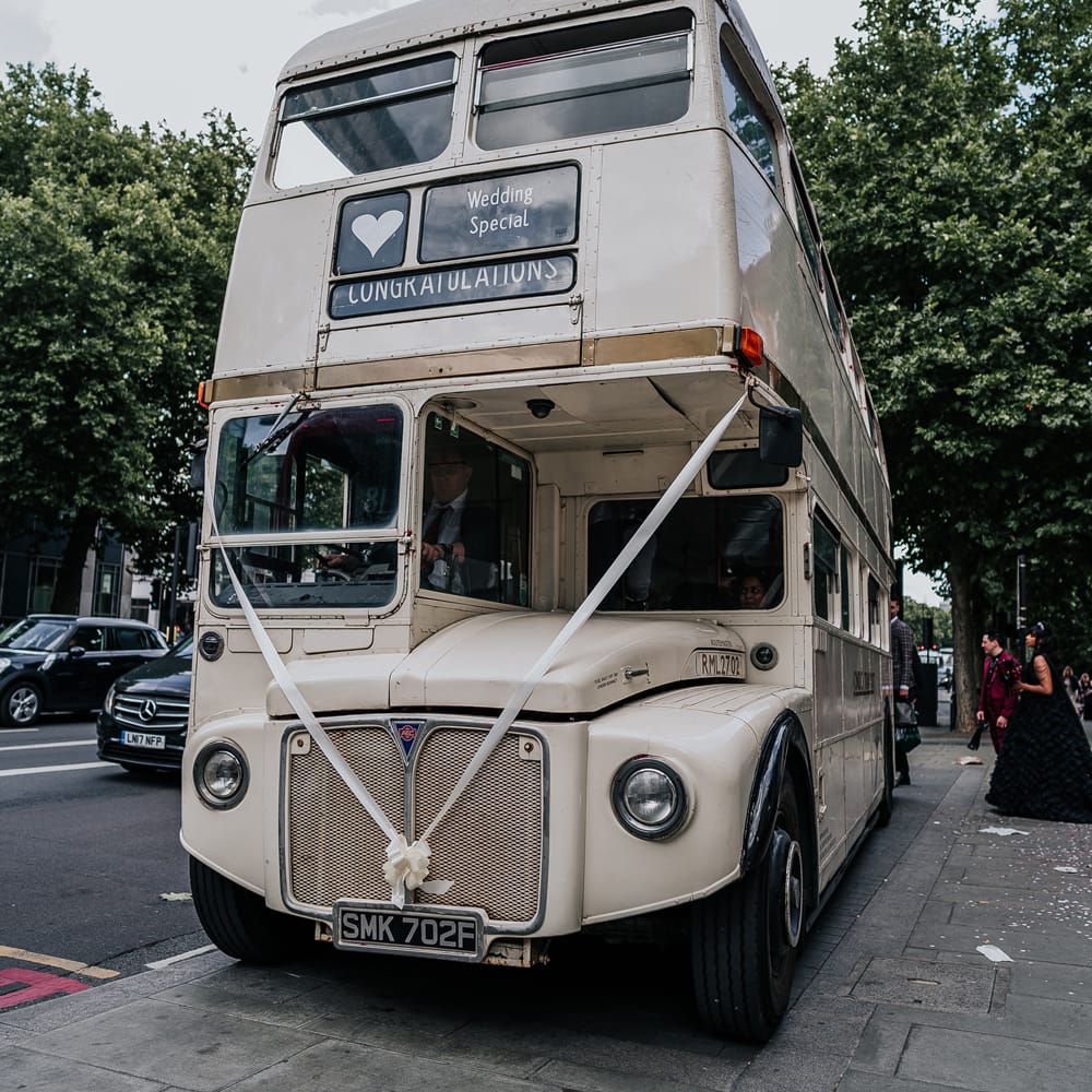 White retro London wedding bus complete with white ribbon to front 