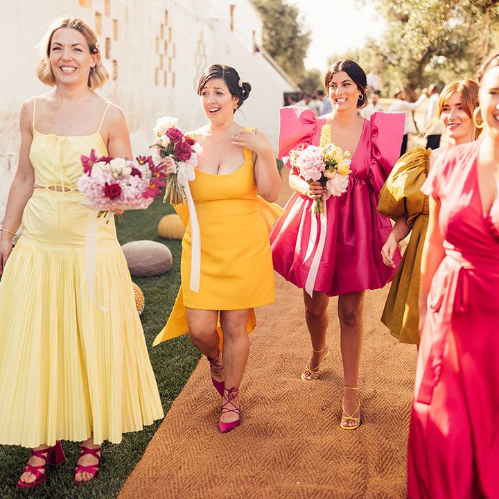 Bridesmaids in bright pink and different shades of yellow bridesmaid dresses