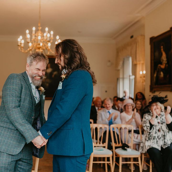 Groom in tartan suit laughs during wedding ceremony 