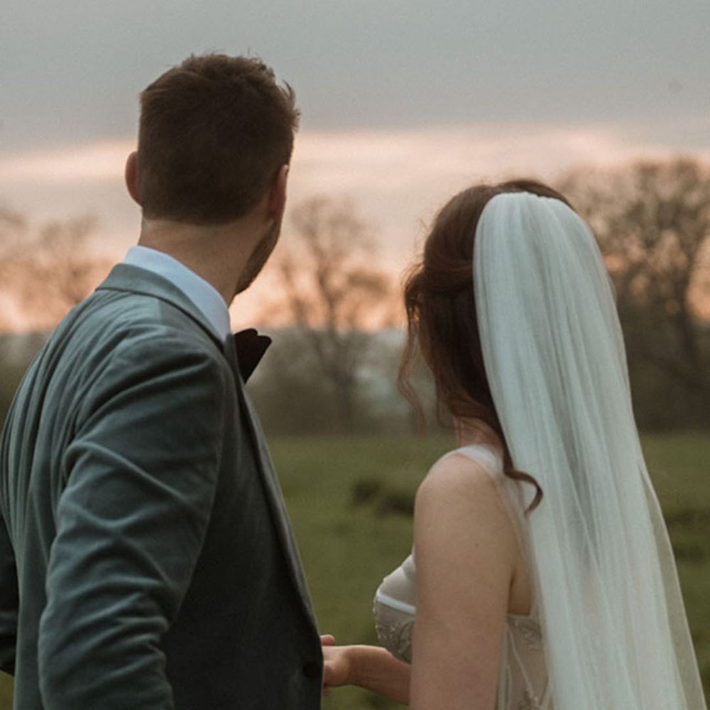 Groom in velvet blazer with bride in sequin corset wedding dress at sunset 