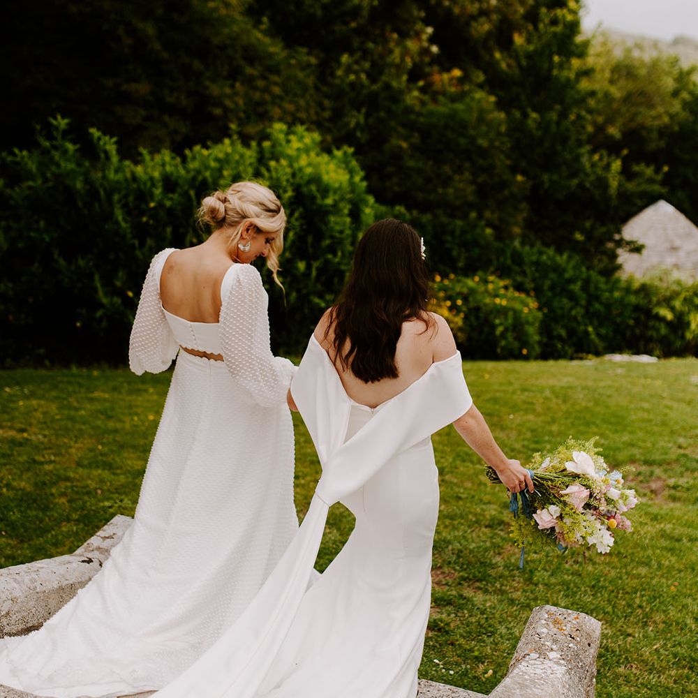 Brides walking around their Dorset wedding venue together at castle wedding 