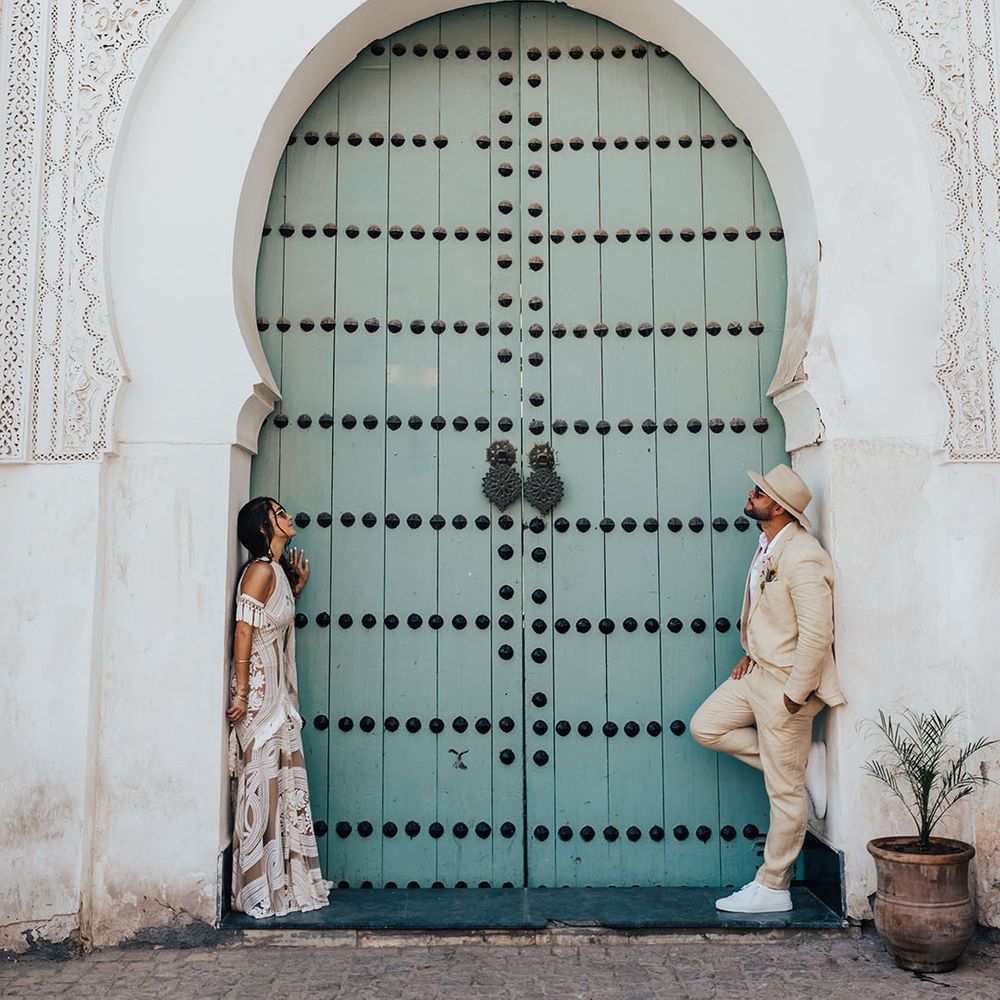 Marrakech destination wedding with the bride and groom posing in front of the blue door 