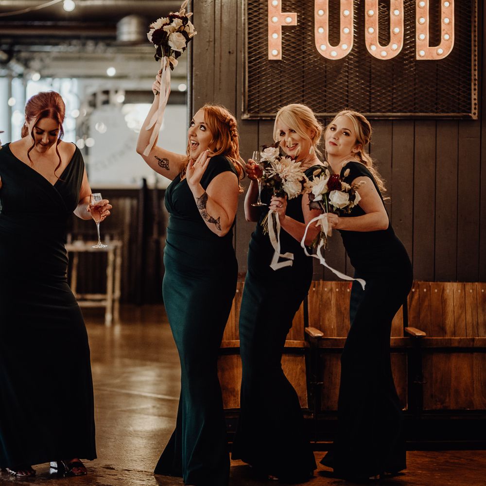 Bridesmaids in deep green off the shoulder dresses with dried flower bouquets 