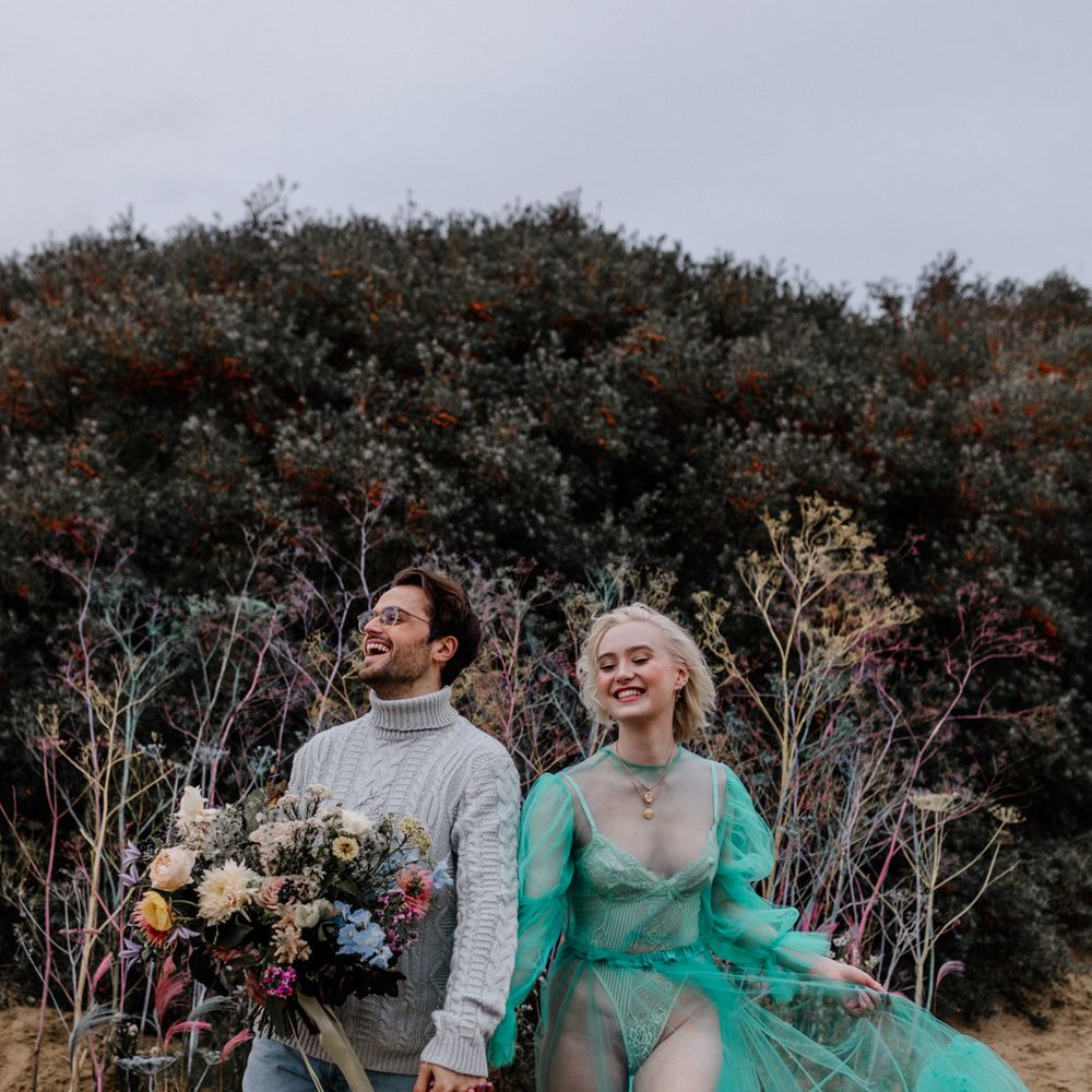 Stylish bride in a all in one and sheer wedding dress for a casual beach elopement 