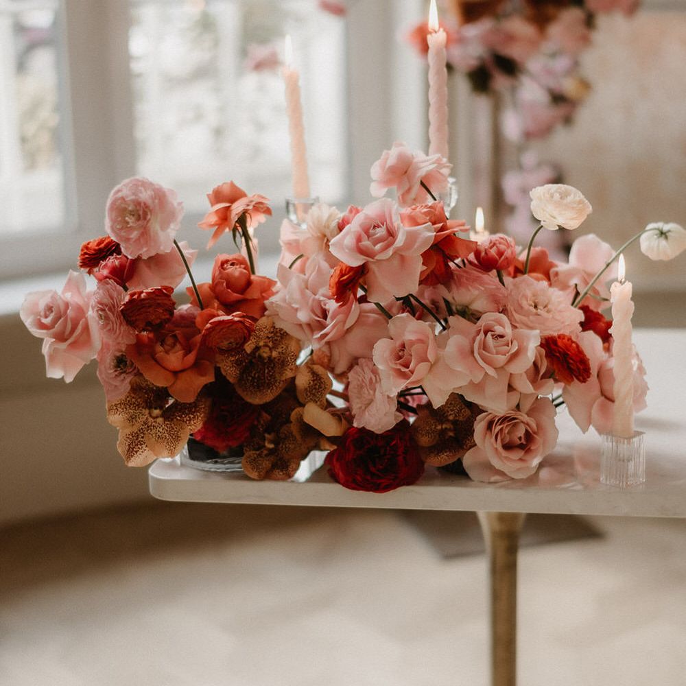 Pink and peach wedding flowers including ranunculi, garden roses and orchids