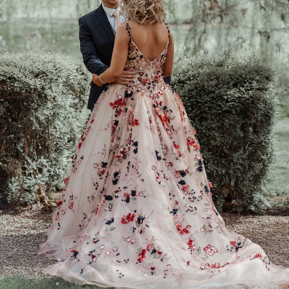Bride & groom stand together outside surrounded by green foliage