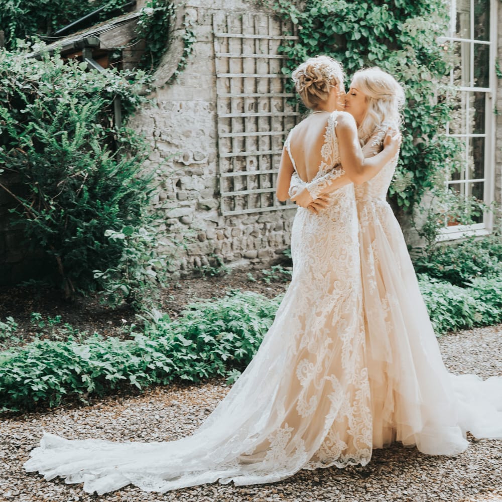 Two brides embrace after a 'first look' before their wedding ceremony at Crab and Lobster Fairytale Wedding.