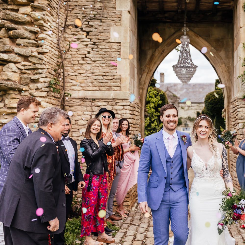 Bride & groom walk through colourful confetti 