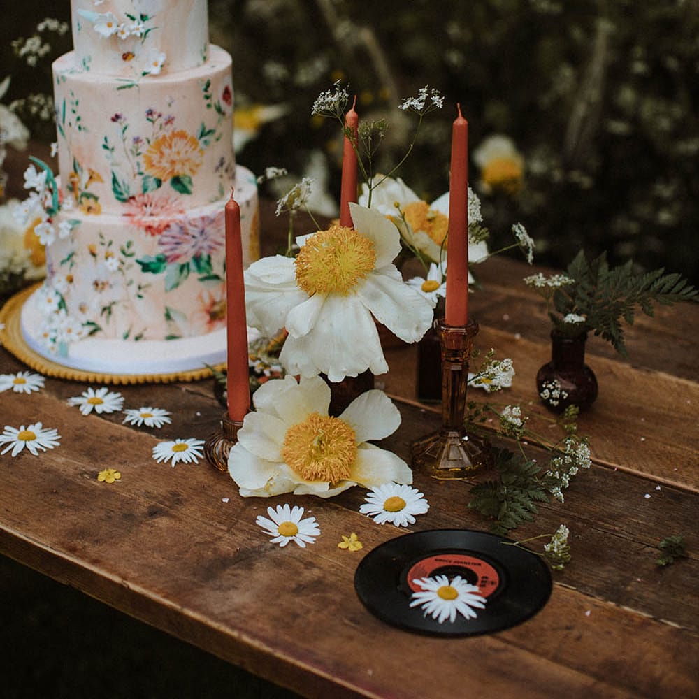 vintage record, candles and wildflower decor on the cake table for sixties wedding inspiration