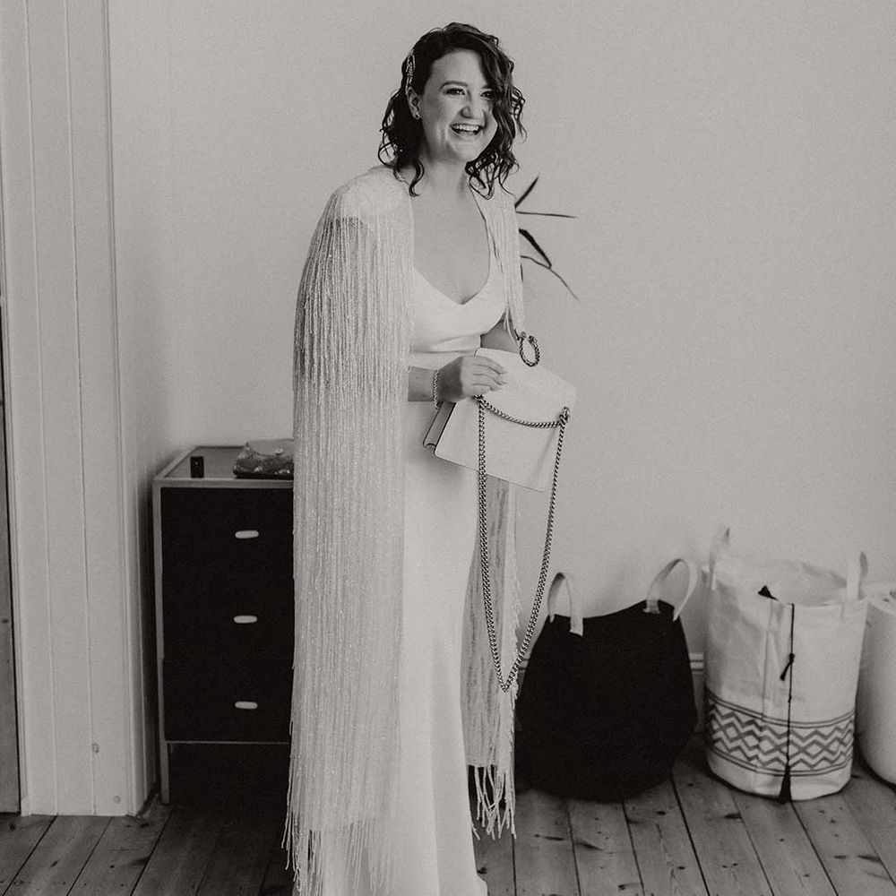 Black & white image of bride wearing wedding cape on her wedding day