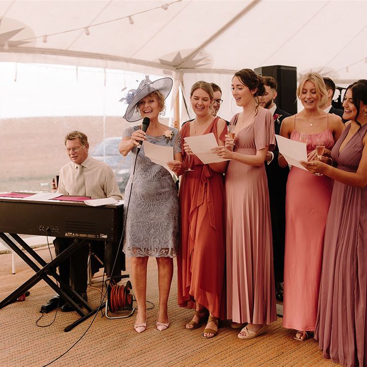 Bridesmaids in mismatched dresses make speech at wedding