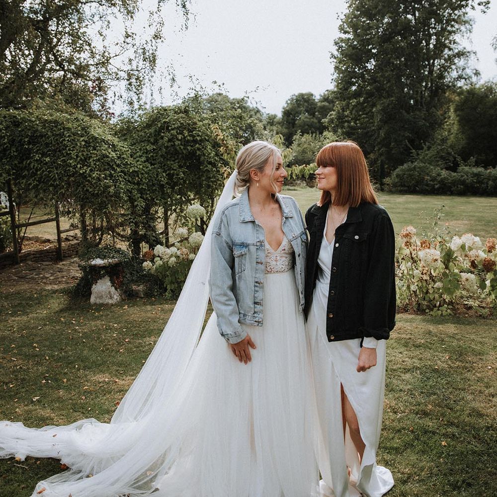 Lesbian wedding with two brides in a princess wedding dress and blue denim jacket and wrap wedding dress with black denim jacket 