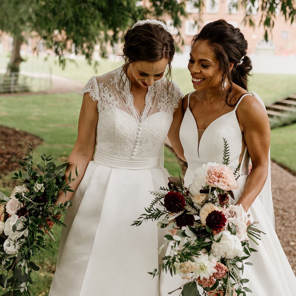 Bride in a princess weddng dress with lace cap sleeves holding hands with her bride in a princess wedding dress with thin straps 