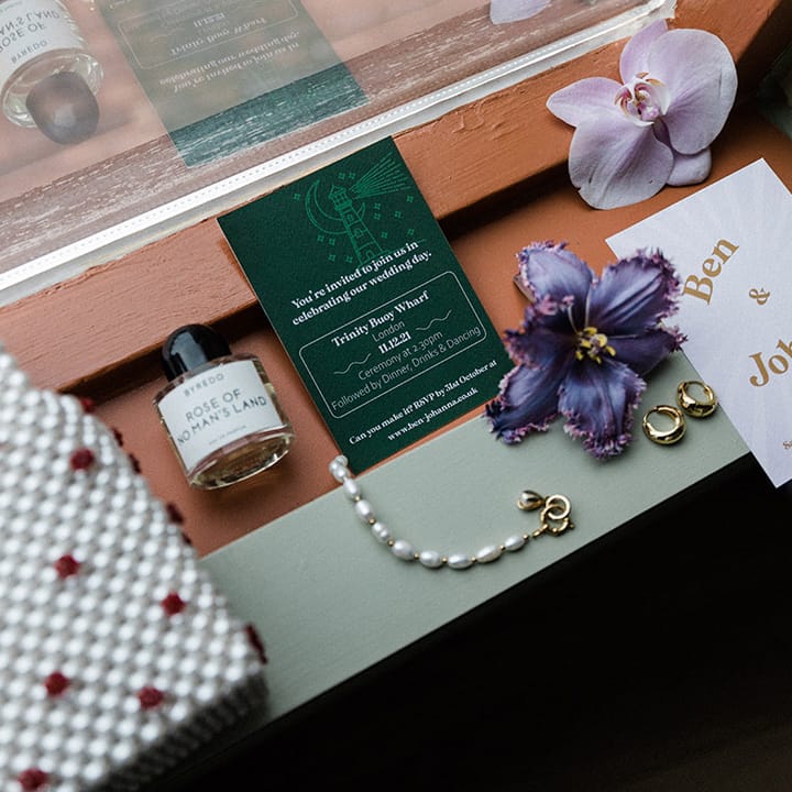 Pearl handbag. bridal accessories and perfume with wedding stationery including invitation and flowers