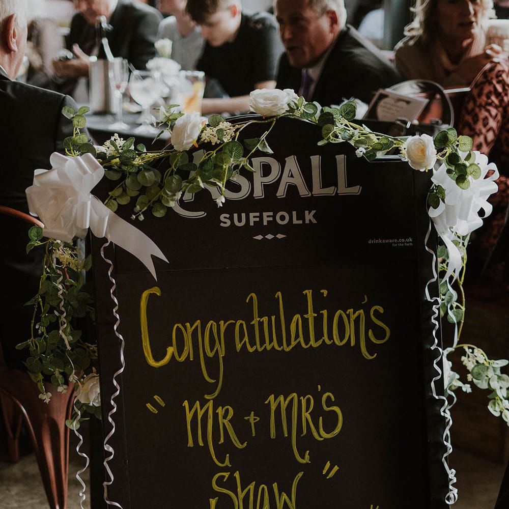 Chalk board pub welcome wedding sign with flower decor 