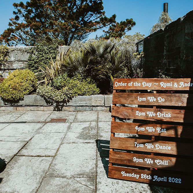 DIY Order Of The Day wooden pallet stands outdoors for Cornish wedding day 