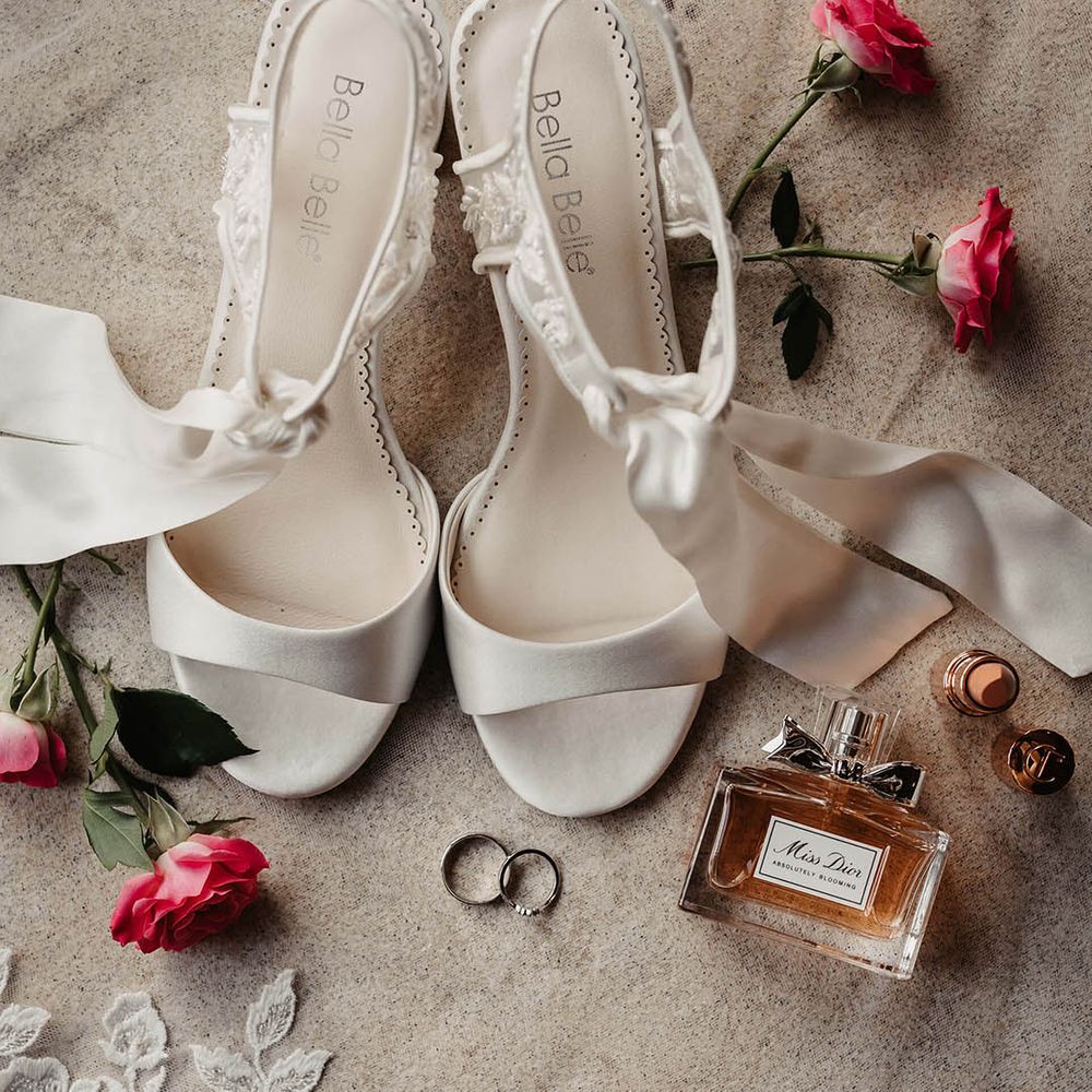 Bridal accessories with white ribbon Bella Belle heels with Dior perfume and Charlotte Tilbury lipstick 