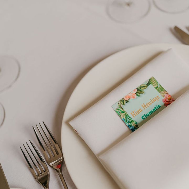 White fabric napkin complete with floral illustrated stationery tucked within 