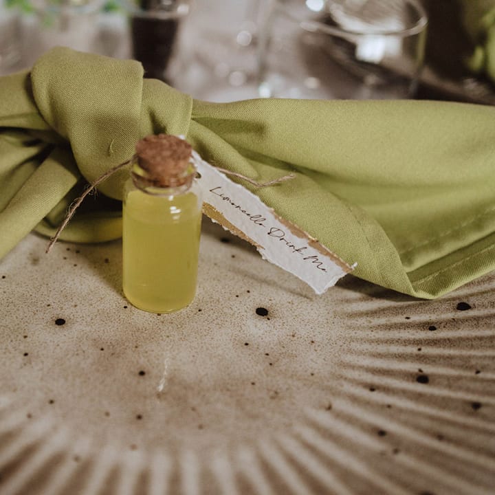 Textured neutral wedding plate with limoncello shot wedding favour and green wedding napkin place setting 