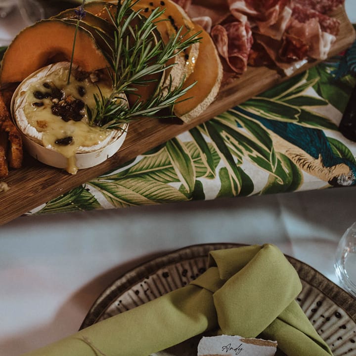 Charcuterie boards with Camembert, melon slices, cured meat, halloumi fries and more on wooden platters on the table 