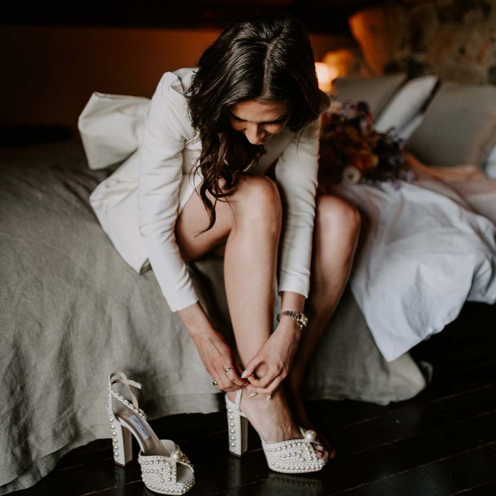 Bride in long sleeve short wedding dress fastening platform pearl wedding heels 