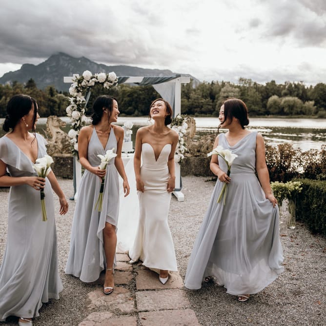 Bridal party portrait with bridesmaids in grey Jenny Too dresses and bride in strapless Reem Acra dress