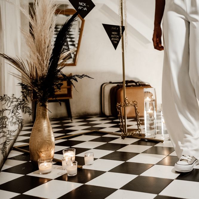 Bride walks through hall with black & white tiles 