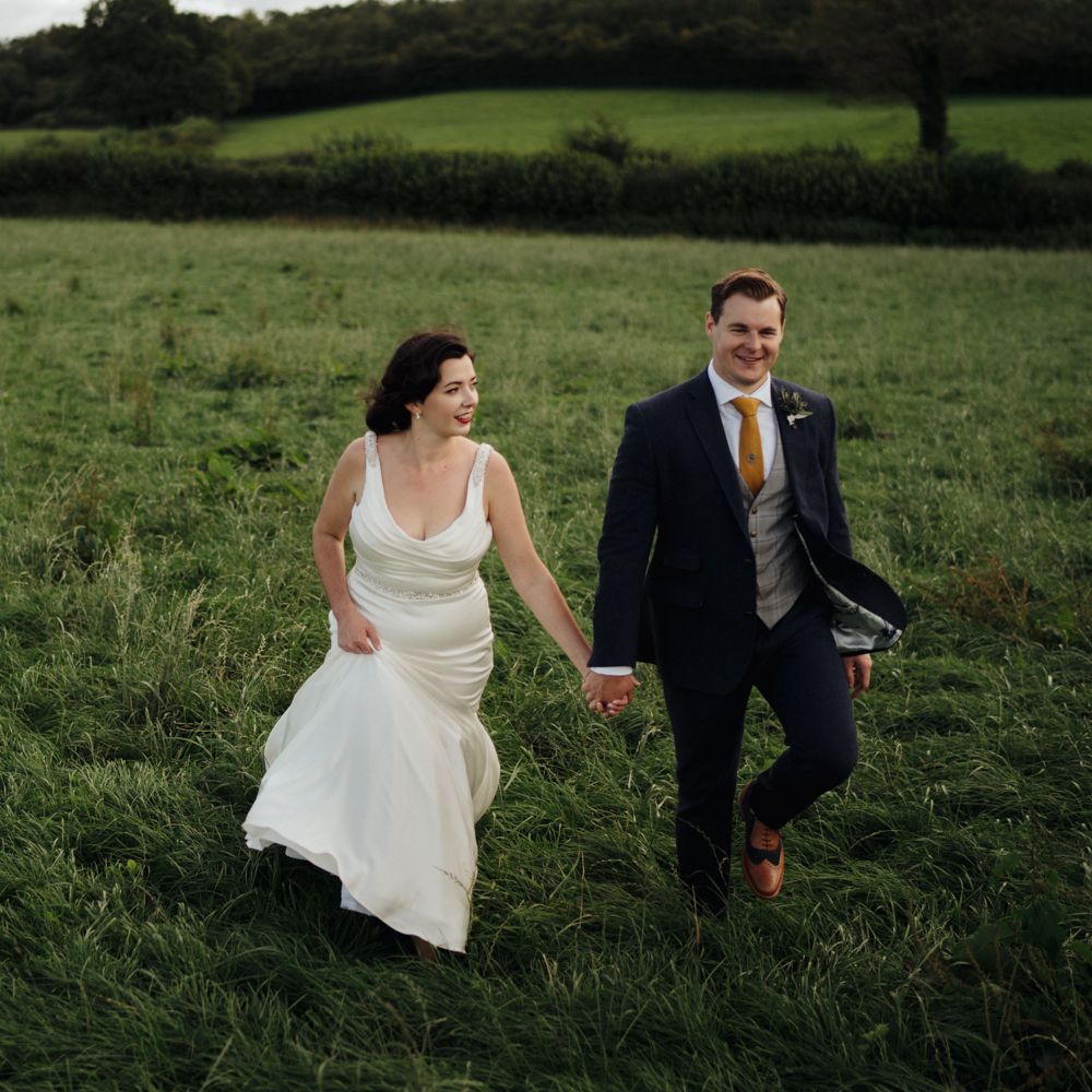 Bride & groom walk through countryside 