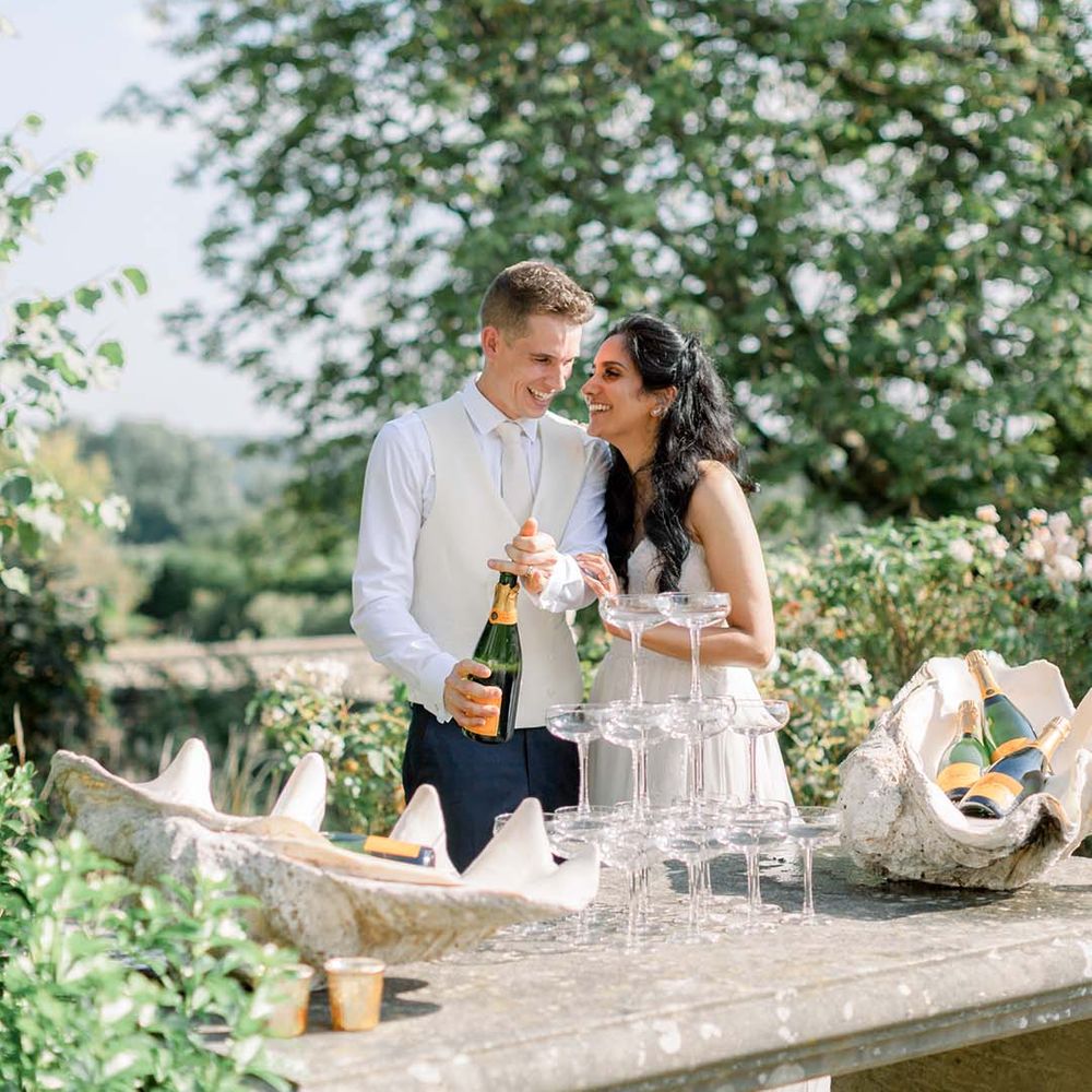 Bride & groom kiss in front of champagne tower 