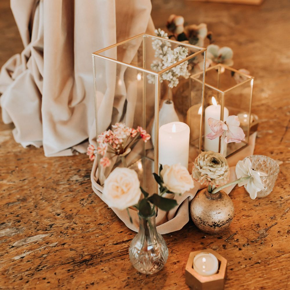 White pillar candles, pastel florals and draping for boho ceremony decor