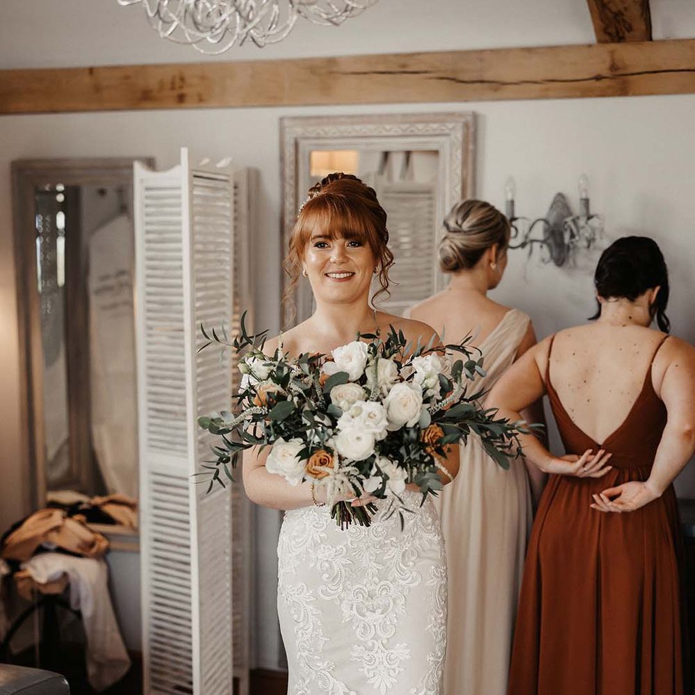 Bride with updo wears lace detailed Maggie Sottero wedding dress and open toe mules 