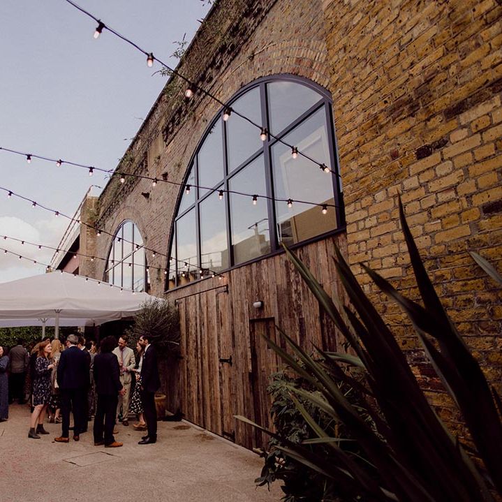 Wedding guests mingle outside the wedding venue, 100 Barrington in Brixton