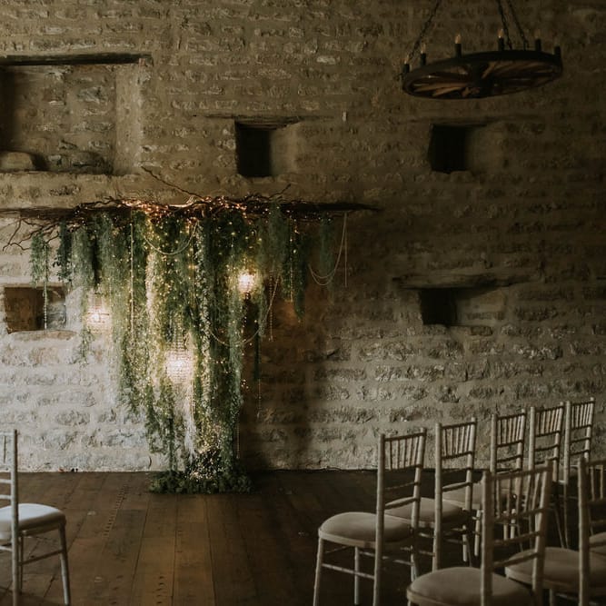 Hooton Pagnell's wedding ceremony room with a fairy light, foliage and twig backdrop