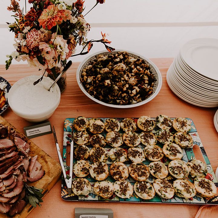 Wedding guests bring dishes to eat for buffet styled wedding breakfast 