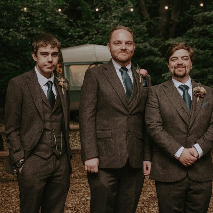 Groom and groomsmen in matching three piece tweed suit with dark green tie 