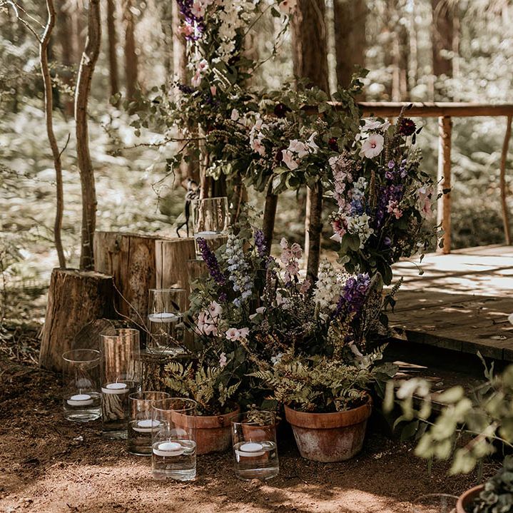 Purple wedding flower decorations with hurricane vases with tea lights decorating the gazebo at Camp Katur 
