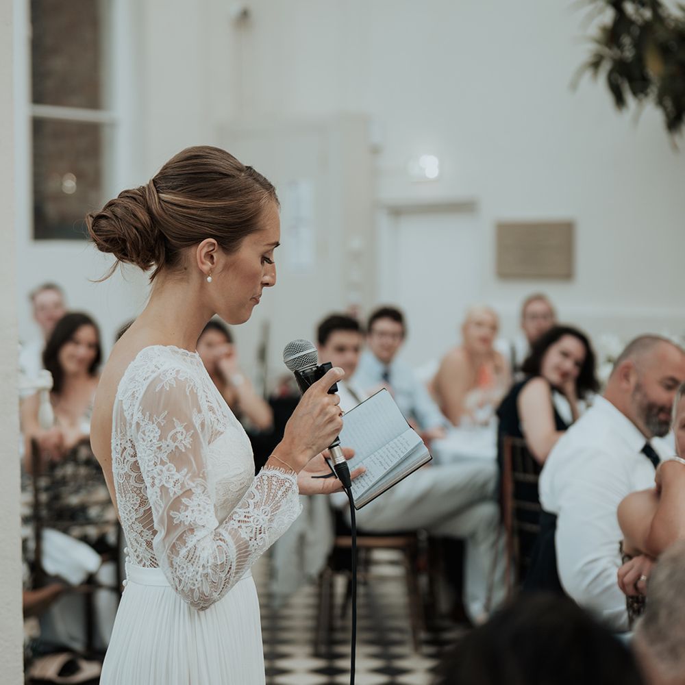 brides speech with long lace sleeves and chic bridal up do wedding hairstyle 