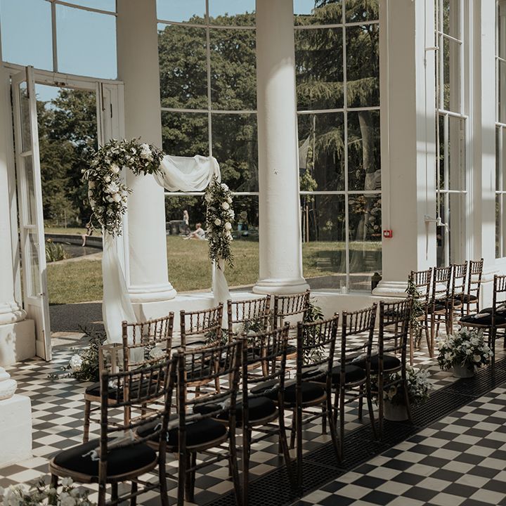 Gunnersbury Park wedding ceremony room with drapes and floral arch altar decoration 