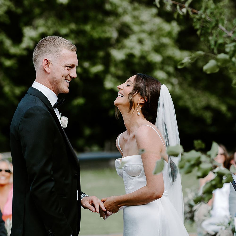 Babington House outdoor wedding ceremony with the bride and groom laughing together 