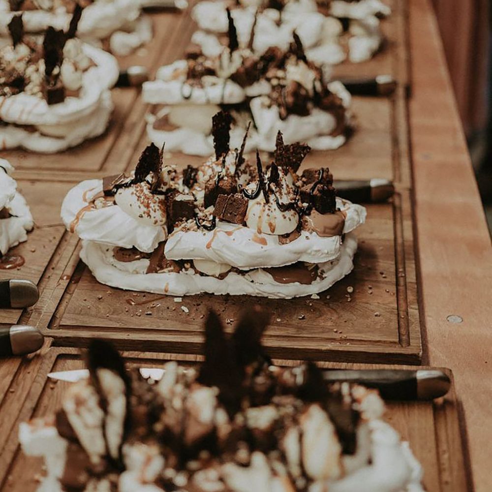 Wedding dessert table with wooden boards for sharing with chocolate brownie pavlova 