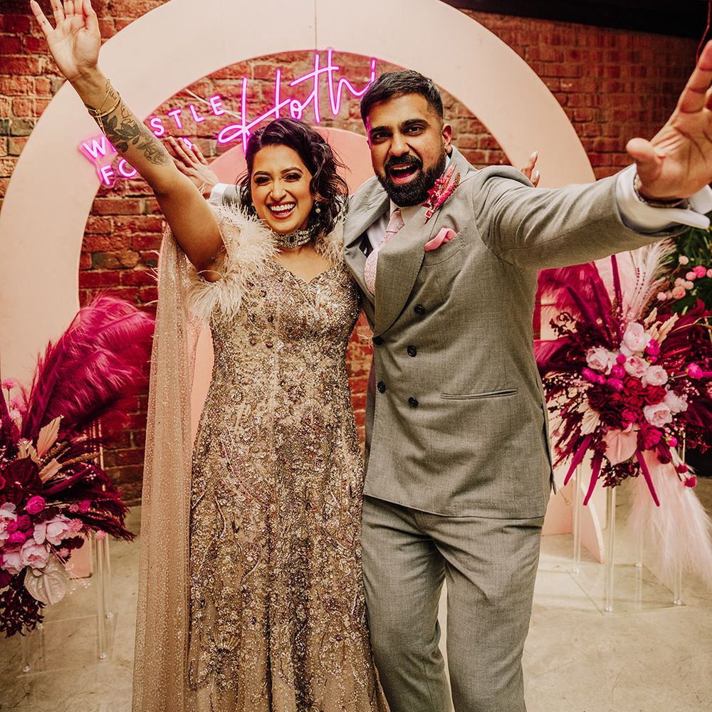 bride-in-sparkly-wedding-dress-with-groom-in-grey-wedding-suit-at-pink-wedding